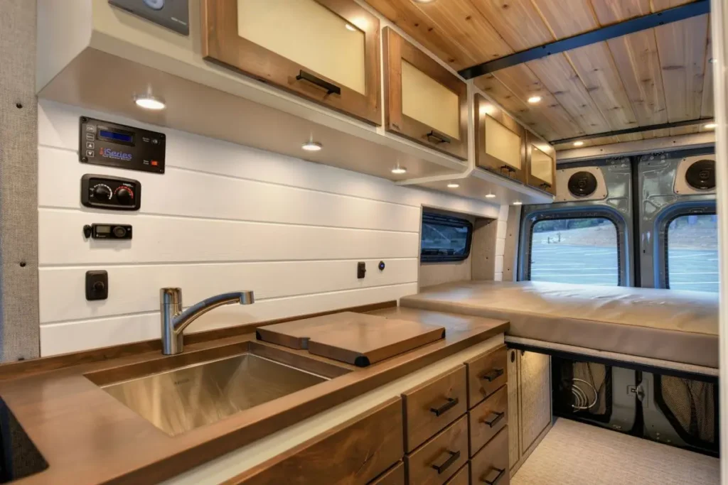 Interior of a campervan with sink and electricity/water meter installed.