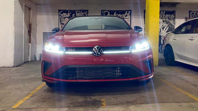 A shot of the front of the GLI in a garage with its lights on showing the light strip that runs the width of the front