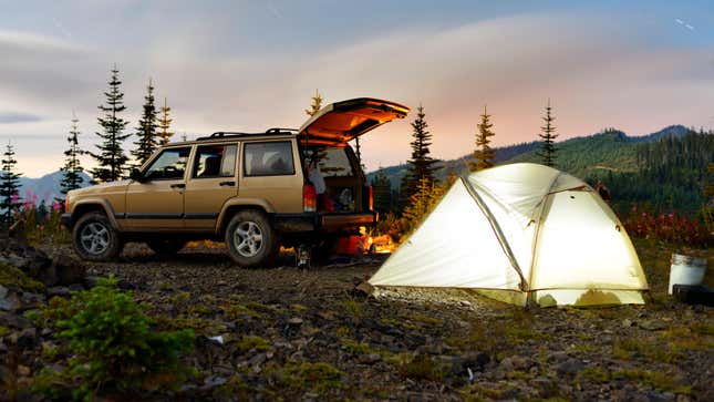 Car parked at camping site against sky at twilight