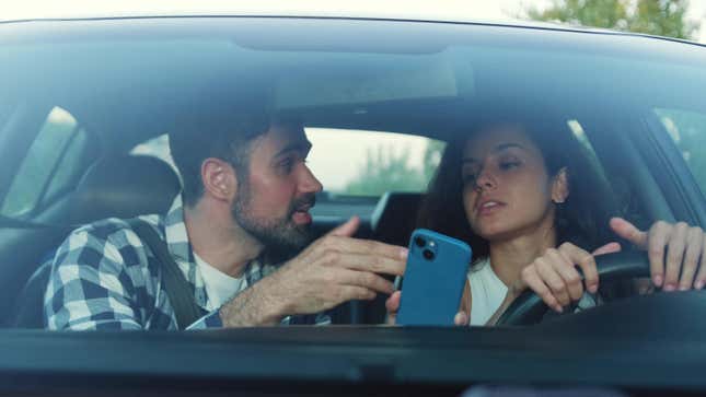 Man explaining to a woman how to get along the route using a navigator on his phone.