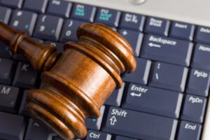 A photo of a gavel resting on a computer keyboard.