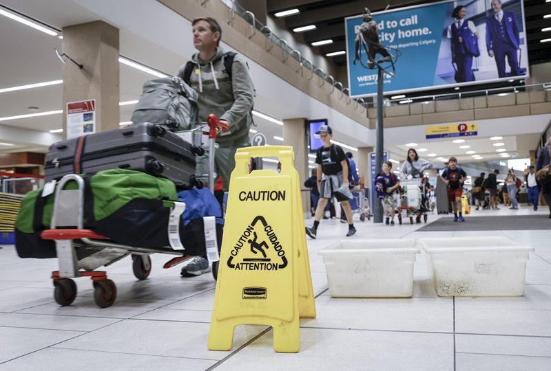 An aviation expert says airfares may rise in the immediate aftermath of a hailstorm that tore through Calgary on Tuesday evening, damaging WestJet planes. Travellers manoeuvre around buckets catching leaks as repairs are underway at the Calgary International Airport after parts of its domestic terminal building were closed late Monday due to damage caused by hail and heavy rainfall, in Calgary, Tuesday, Aug. 6, 2024. THE CANADIAN PRESS/Jeff McIntosh