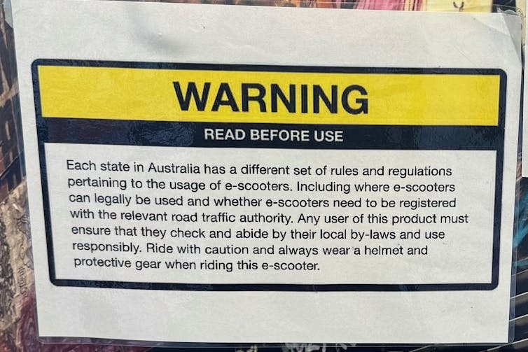 A warning sign in a shop about the rules governing use of the e-scooters it's selling