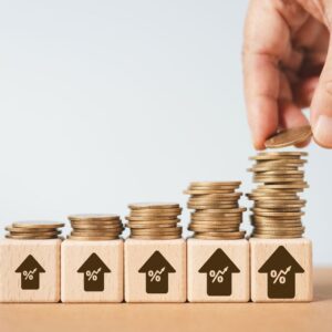 increasing stacks of coins on top of wooden blocks with up arrows representing growth