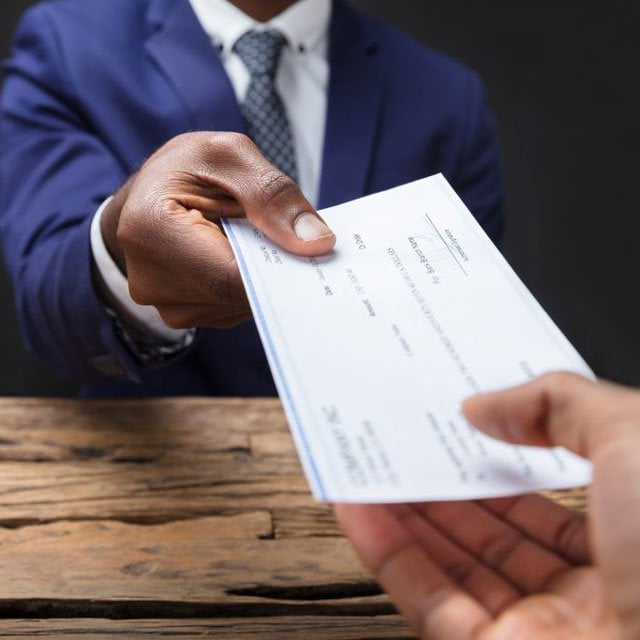 Businessman giving employee a check