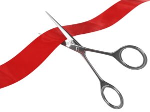 Scissors cutting red ribbon