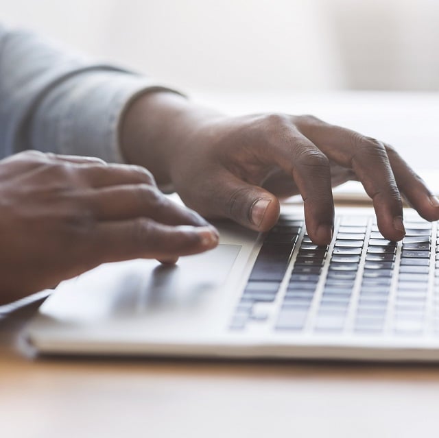 hands typing on laptop keyboard