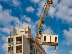 Crane lifting modular segment into place on a housing project