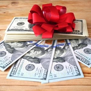 Stack of money with gift bow