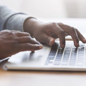 Someone typing on a computer (Image: Prostock-studio/Adobe)