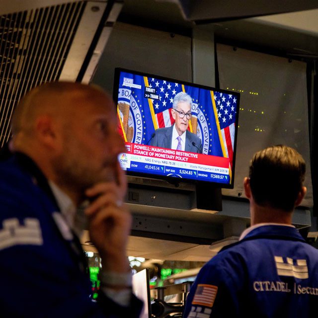 Trader watching Fed Chairman Powell on a TV at the New York Stock Exchange