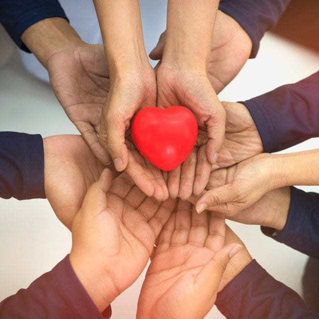 A heart held up by hands