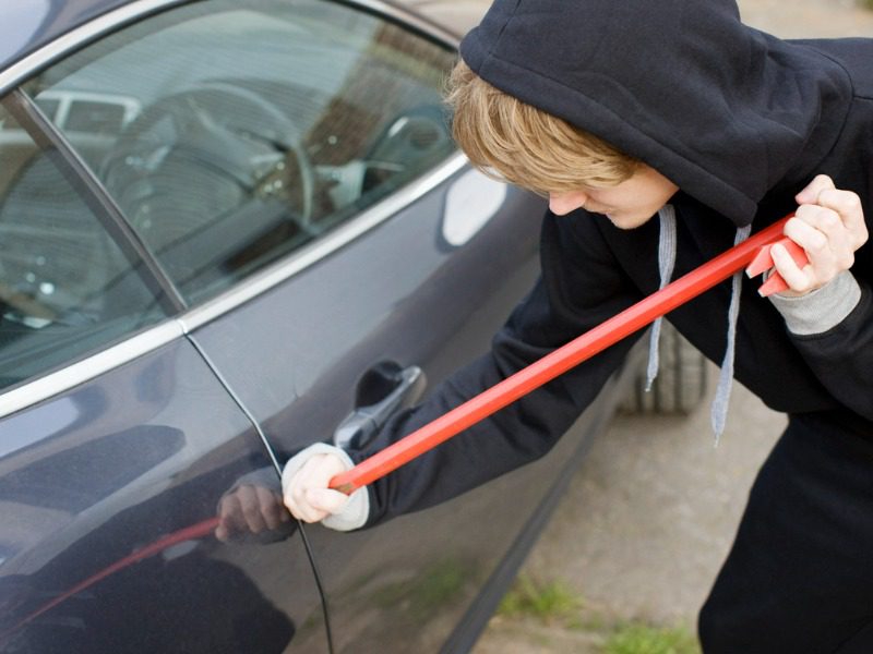 Thief stealing a car with a crowbar