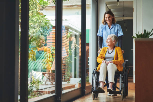 Shot of a young nurse pushing a senior woman in a wheelchair in a retirement home Caregiving leads to a selfless, rewarding life health insurance stock pictures, royalty-free photos & images