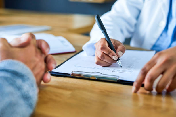 Compiling a thorough plan towards her patient's healing Closeup shot of a doctor writing notes during a consultation with a patient health insurance stock pictures, royalty-free photos & images