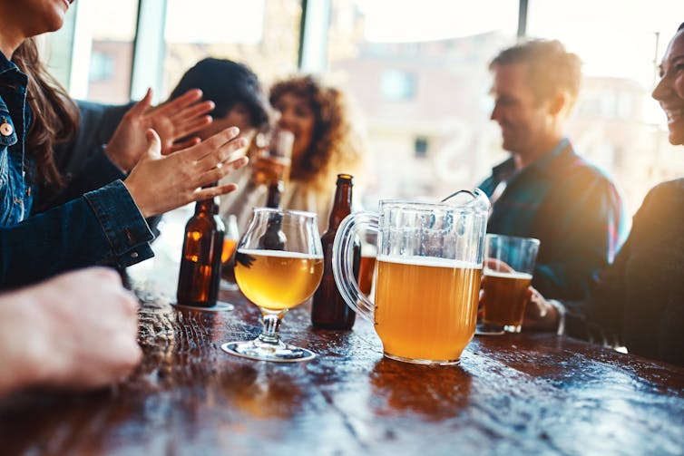 People enjoy a jug of beer at a pub.