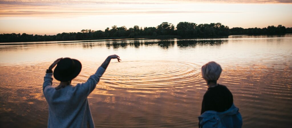 Girlfriends throwing stones in river water