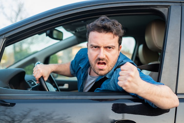 A man gestures angrily at another driver.