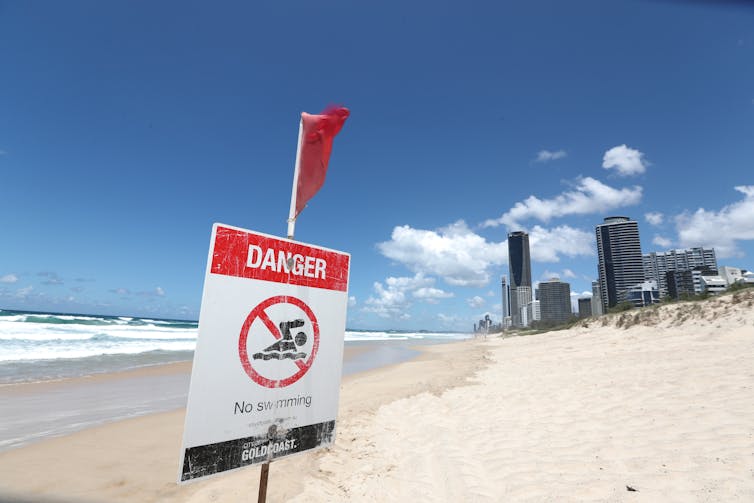 sign on beach reading 'Danger: no swimming'