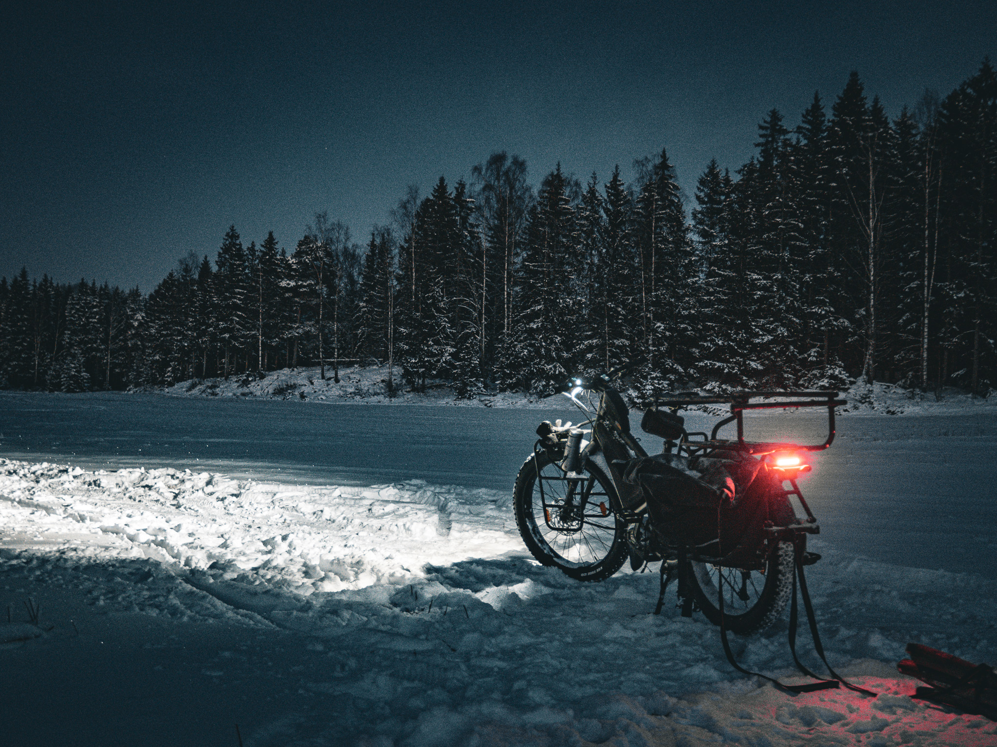 A Cargo bike with bright lights in the snow