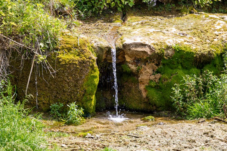 Stream of water flowing from a shelf of rocks