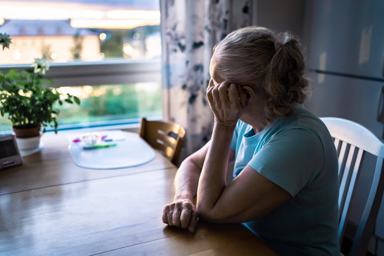 A woman sitting at a table looking out the window.