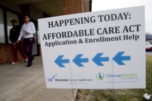 An Affordable Care Act application and enrollment help sign outside of a building.